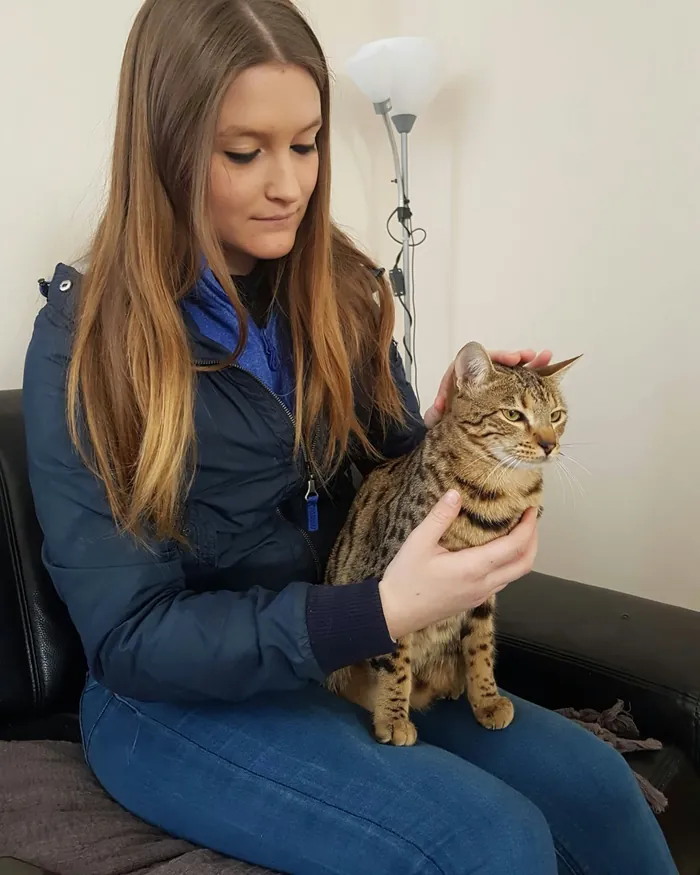 Marie Clément avec un chat tigré sur les genoux